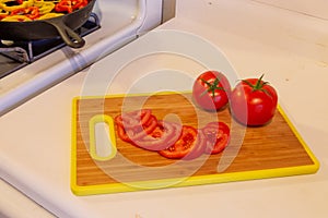 Closeup of fresh ripe whote and sliced tomatoes on a cutting board