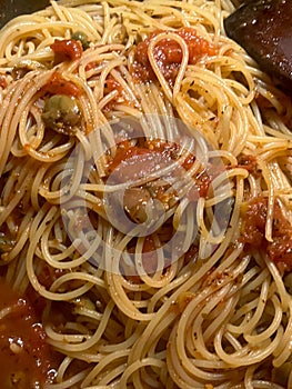 Closeup of fresh spaghetti putanesca with selective focus on foreground photo