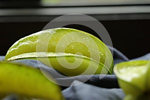 Closeup of fresh star fruit. Averrhoa carambola and dark blue cloth on wooden table. Healthy food.