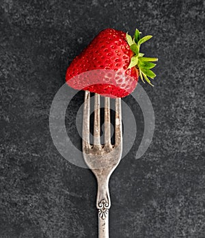 Strawberry on a vintage fork with a patina photo