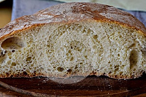 Closeup of freshly baked bread in rustic style/ Fresh round bread with a beautiful crust lies on a wooden board/ Homemade bread -