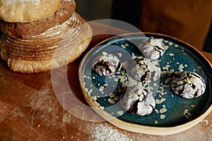 Closeup freshly made cookies on plate and bread on wooden table