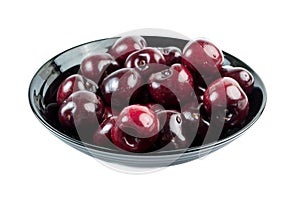 Closeup of freshly washed ripe cherries in a black bowl isolated on white background