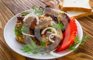 Closeup fried chicken wings, with fresh tomatoes, onions, dill, garlic and bread on a wooden background. The concept of meat food