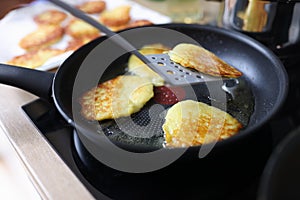 Closeup of fried potato pancakes in frying pan