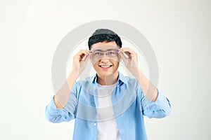 Closeup of friendly guy wearing eyeglasses. Young asian man adjusting glasses and staring at camera through lens. Vision and eye