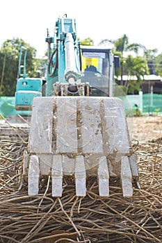 Closeup front loader truck collecting old steel bar from construction site, clearing space