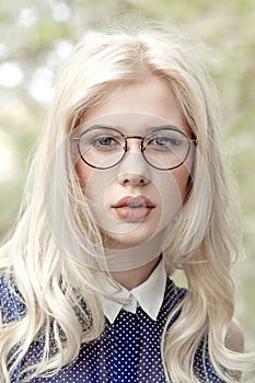 Closeup front portrait of a beautiful young woman in trendy eye glasses.