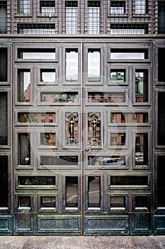 Closeup front view of a beautiful vintage ornate steel brass door with glass and square pattern.