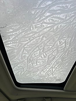 Closeup of the frost, frozen glass of the car sunroof