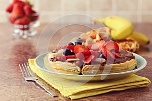 Closeup of fruit waffle with chocolate spread and a fork