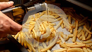 Closeup of frying french fries potato on baking pan in oven. Fast food, healthy nutrition, cooking in oven