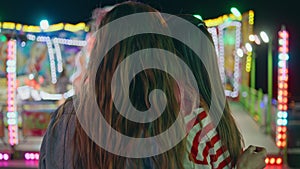 Closeup fun friends resting colourful amusement luna park. Two girls hang out