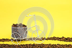 Closeup of a funny bicycle bowl with coffee beans on a yellow background