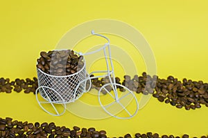 Closeup of a funny bicycle bowl with coffee beans on a yellow background