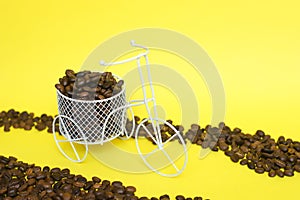 Closeup of a funny bicycle bowl with coffee beans on a yellow background