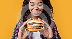 Closeup Of Funny Black Lady Holding Burger At Studio
