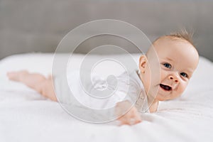 Closeup of funny newborn baby 4 month laying on stomach developing neck control .Tummy time for strengthen baby neck and