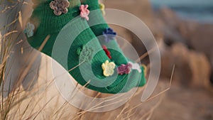 Closeup funny socks moving in summer sunlight. Woman legs wearing colorful pair