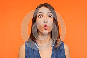 Closeup of funny stupid brunette woman making fish face, looking with big amazed shocked eyes and idiotic silly expression