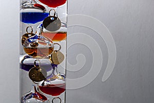 Closeup of a Galileo thermometer against white background with space for your text