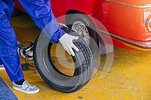 closeup garage mechanic worker replace car tyre change replace rubber wheels in auto service center concept