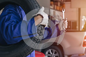 closeup garage mechanic worker replace car tyre change replace rubber wheels in auto service center concept