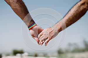 closeup of a gay couple holding hands, Rainbow flag is a symbol of lesbian, gay, bisexual, and transgender. LGTB,LGBT