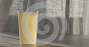 closeup ginger beer in a tumbler glass on oak table with copy space