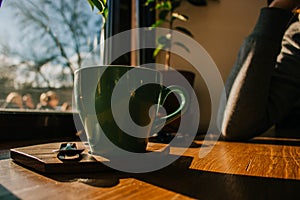 Closeup of a girl at cafe holding a cup of cappuccino coffee. Millenial styled photo