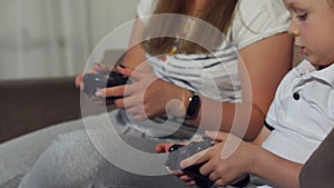 Closeup of a girl with a child playing video games with joysticks in their hands