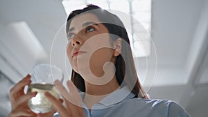 Closeup girl drinking water at lamp light. Beautiful office manager rest break