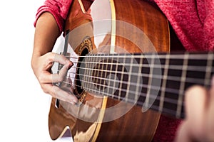 Closeup of girlÃÂ´s hands playing acoustic quitar photo