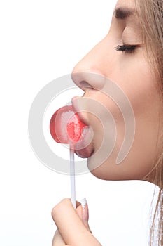 Closeup girl sucks a lollipop.