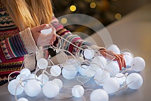 Closeup on girl untangling christmas lights