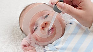Closeup of giving vaccine to newborn baby boy from eyedropper or syringe. Concept of babies and newborn vaccination and