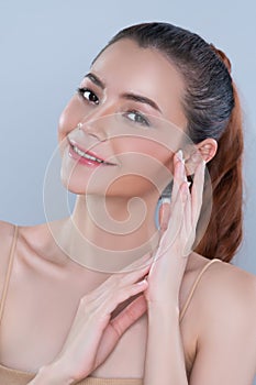 Closeup glamorous woman applying moisturizer cream on her face for perfect skin