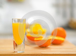 Closeup on glass of fresh orange juice and oranges