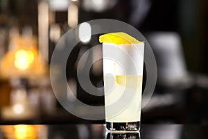 Closeup glass of gin fizz cocktail with lemon and whip eggwhite