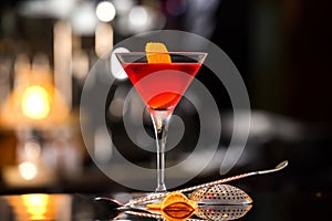 Closeup glass of Manhattan cocktail decorated with orange