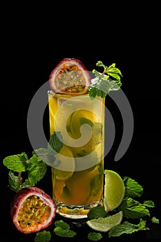 Mojito with passion fruit  maracuya  lime and green leaf mint isolated on black background