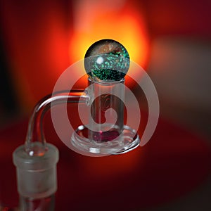 Closeup of a glass smoking banger on blur red background