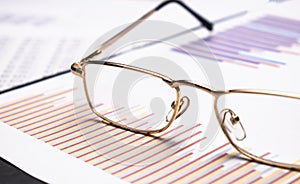 closeup glasses on financial newspaper under light tint blue