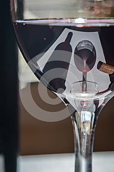 Closeup of glasses of red wine and bottle with shadows and reflections