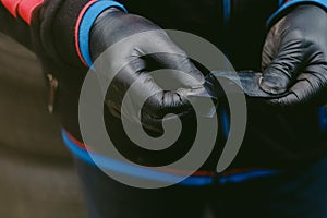 Closeup of a gloved worked opening a radial tire patch in a workshop