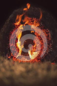 Closeup of glowing log embers and flames creating a fiery abstract background