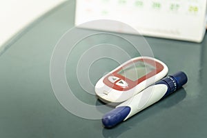 Closeup of Glucose meter with lancet with calendar as background. Use as Schedule, Medicine, diabetes, glycemia, health care and