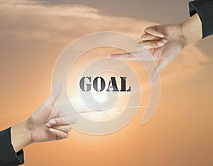 Closeup goal word at the center frame by hand of working woman on beautiful evening sky textured background in work concept