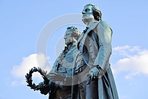 Closeup of Goethe-Schiller-Denkmal monument on blue cloudy sky background in Germany