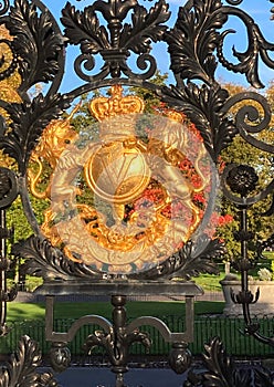 Closeup of the gold coloured insignia on the entrance gate to Kew Gardens, near London
